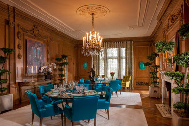 This is an example of an expansive classic enclosed dining room in Los Angeles with medium hardwood flooring, a standard fireplace, brown walls and a stone fireplace surround.