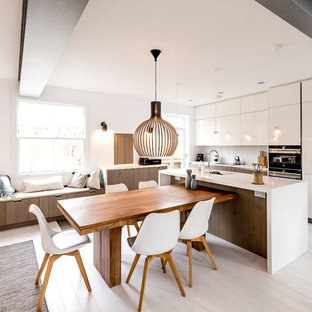 This is an example of a contemporary kitchen/dining room in London with white walls, painted wood flooring and white floors.