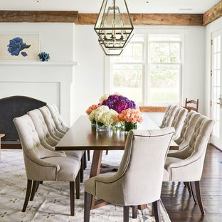 Design ideas for a country dining room in Los Angeles with white walls, dark hardwood floors, a standard fireplace and brown floor.
