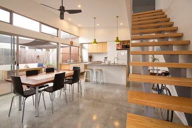 Esempio di una piccola sala da pranzo aperta verso la cucina contemporanea con pareti bianche e pavimento in cemento