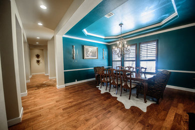 Large elegant medium tone wood floor and brown floor dining room photo in Austin with blue walls and a wood fireplace surround