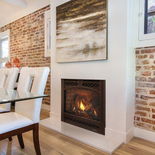Mid-sized urban light wood floor and brown floor kitchen/dining room combo photo in Milwaukee with a standard fireplace and a plaster fireplace