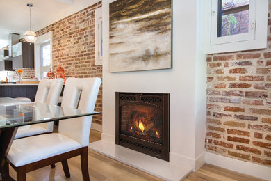 Inspiration for an industrial light wood floor and beige floor dining room remodel in Boston with red walls, a standard fireplace and a concrete fireplace