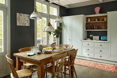 Esempio di una grande sala da pranzo aperta verso il soggiorno scandinava con pavimento in legno massello medio, pavimento marrone e pareti verdi