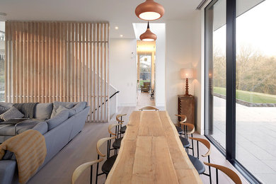 Large contemporary open plan dining room in London with white walls and no fireplace.