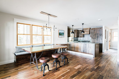 Esempio di una sala da pranzo aperta verso la cucina stile rurale con pareti bianche, parquet scuro e pavimento marrone