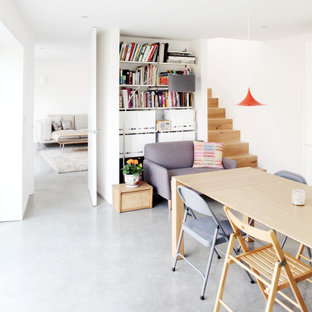 Design ideas for a medium sized contemporary open plan dining room in Kent with white walls and grey floors.