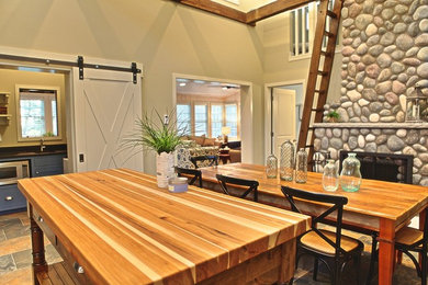 Ispirazione per una piccola sala da pranzo aperta verso la cucina stile marino con pareti beige, camino classico e cornice del camino in pietra