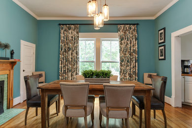 Enclosed dining room - mid-sized transitional medium tone wood floor and brown floor enclosed dining room idea in Raleigh with blue walls, a standard fireplace and a tile fireplace