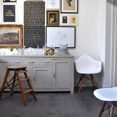 Example of an eclectic ceramic tile dining room design in London with white walls