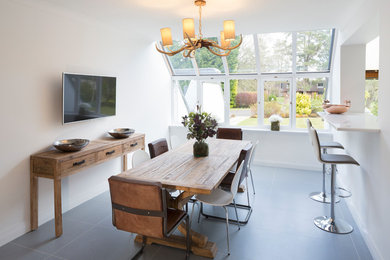 Photo of a medium sized contemporary dining room in Other with white walls and grey floors.