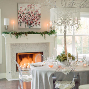 Example of a transitional dark wood floor and brown floor dining room design in Cleveland with beige walls and a standard fireplace