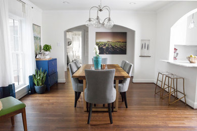 Example of a mid-sized eclectic medium tone wood floor and brown floor kitchen/dining room combo design in Dallas with white walls and no fireplace