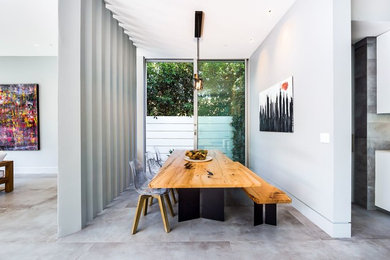 Diseño de comedor contemporáneo con paredes blancas, suelo de cemento y suelo gris