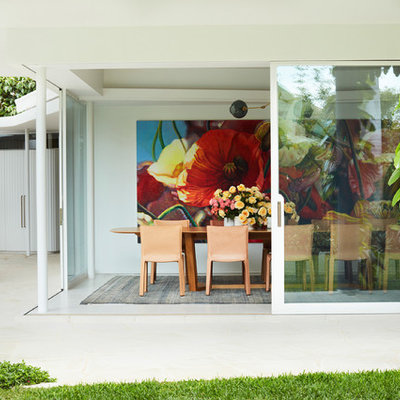 Example of a minimalist white floor dining room design in Sydney with white walls