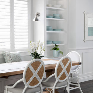 Idee per un grande angolo colazione chic con pareti bianche, parquet scuro, pavimento marrone e boiserie