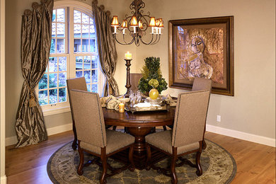 Mid-sized elegant medium tone wood floor enclosed dining room photo in Denver with beige walls and no fireplace