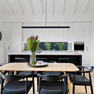 Design ideas for a contemporary open plan dining in Melbourne with white walls, light hardwood floors and beige floor.