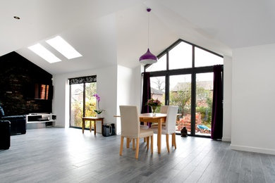This is an example of a large contemporary dining room in Cheshire with white walls and light hardwood flooring.