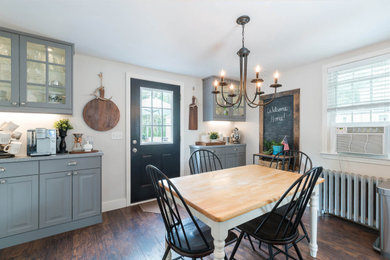 Example of a mid-sized country laminate floor and shiplap wall kitchen/dining room combo design in Bridgeport with gray walls