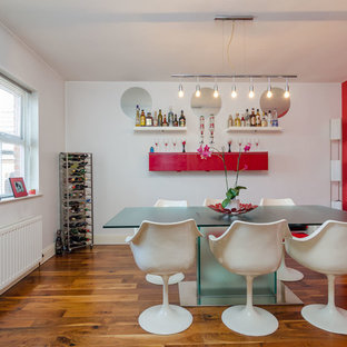 Photo of a contemporary dining room in Belfast with red walls, medium hardwood flooring and no fireplace.