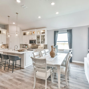 Exemple d'une salle à manger tendance de taille moyenne avec une banquette d'angle, un mur blanc, un sol en bois clair et un sol beige.
