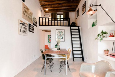 Свежая идея для дизайна: гостиная-столовая среднего размера в средиземноморском стиле с белыми стенами и бетонным полом без камина - отличное фото интерьера