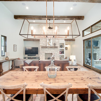 Mid-sized country light wood floor and brown floor great room photo in Austin with white walls and no fireplace