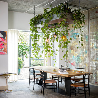 Immagine di una sala da pranzo eclettica con pareti bianche e pavimento grigio
