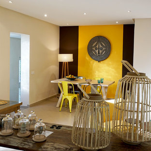 Mittelgroßes Shabby-Chic-Style Esszimmer mit gelber Wandfarbe, Kaminofen, Kaminumrandung aus Metall und beigem Boden in Sonstige