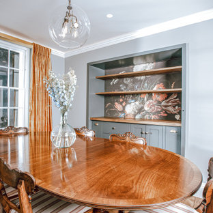 Ispirazione per una grande sala da pranzo tradizionale chiusa con pareti grigie, parquet scuro, camino classico, cornice del camino in metallo, pavimento marrone e pannellatura