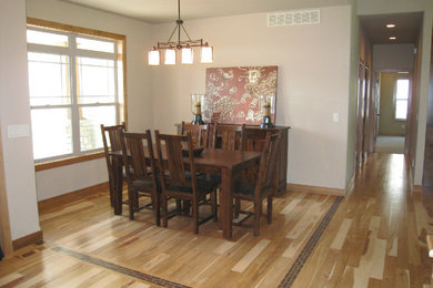 Mid-sized elegant medium tone wood floor and brown floor dining room photo in Cedar Rapids with white walls and no fireplace