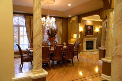 This is an example of a mediterranean kitchen/dining room in New York with brown walls, light hardwood flooring and a standard fireplace.