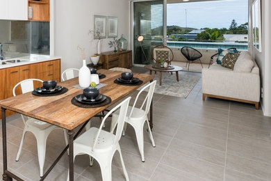 Cette photo montre une petite salle à manger ouverte sur le salon tendance avec un mur blanc, un sol en carrelage de céramique et un sol gris.