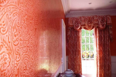 Photo of a traditional dining room in Miami with orange walls.