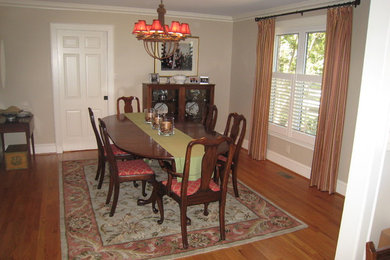 Example of a mid-sized classic medium tone wood floor enclosed dining room design in Other with beige walls