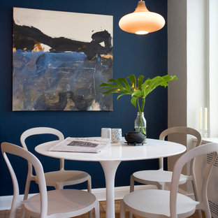 Immagine di una sala da pranzo minimal con pareti blu e pavimento in legno massello medio