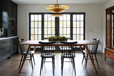 This is an example of a medium sized contemporary kitchen/dining room in New York with white walls, medium hardwood flooring and grey floors.