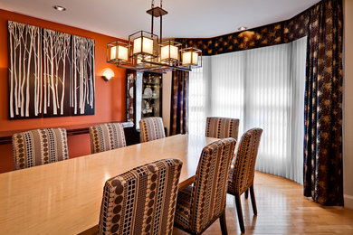 Example of a large trendy light wood floor enclosed dining room design in Baltimore with no fireplace and multicolored walls