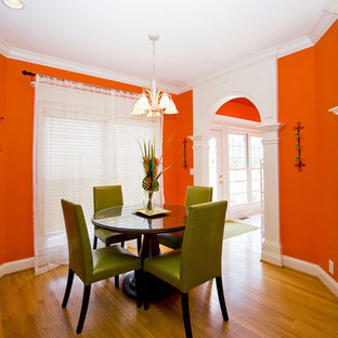 Cette image montre une salle à manger bohème avec un mur orange et un sol en bois brun.