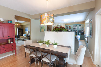 Cette image montre une salle à manger ouverte sur la cuisine rustique de taille moyenne avec parquet clair et un mur beige.