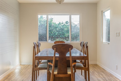 Example of a mid-sized minimalist light wood floor enclosed dining room design in Los Angeles