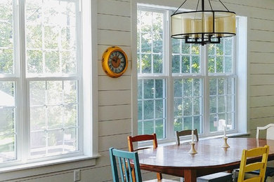 Cette image montre une salle à manger ouverte sur le salon rustique de taille moyenne avec un mur blanc, parquet foncé, aucune cheminée et un sol noir.