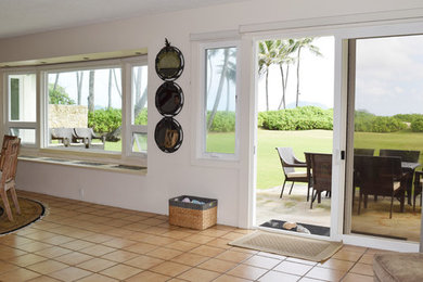 ハワイにあるお手頃価格の中くらいなビーチスタイルのおしゃれなダイニングキッチン (白い壁、テラコッタタイルの床、暖炉なし) の写真