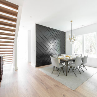 Esempio di una sala da pranzo aperta verso la cucina design con pareti nere e pavimento in laminato