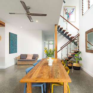 This is an example of an eclectic kitchen/dining combo in Brisbane with white walls and grey floor.