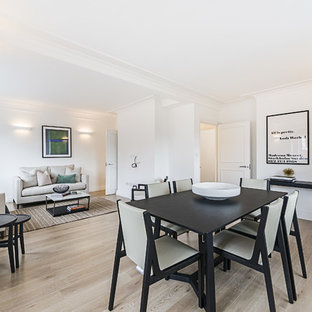 Photo of a medium sized modern dining room in London with white walls, light hardwood flooring and beige floors.