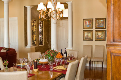 Modelo de comedor clásico renovado con paredes amarillas y suelo de madera en tonos medios