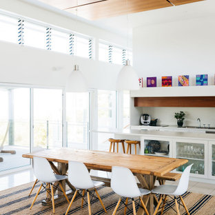 Photo of a contemporary open plan dining in Wollongong with white walls, beige floor and wood.