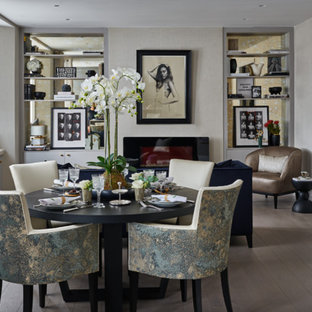 Cette image montre une salle à manger traditionnelle de taille moyenne avec un mur beige, un sol en bois clair et une cheminée ribbon.